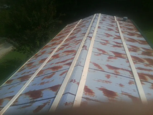 Rusted metal roof panels with new wood purlins before replacement — Storm Damage Roof Repair in Ruffin by Roofing Brothers