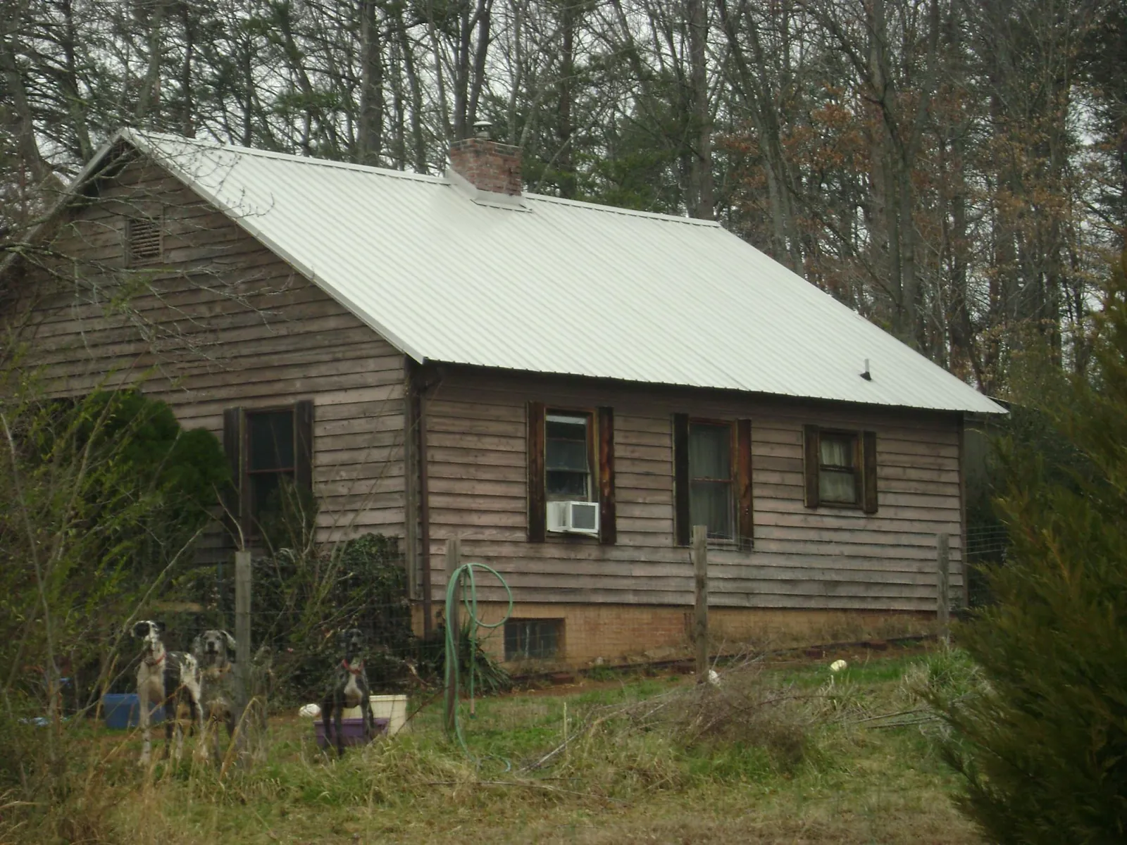White metal roof on an old wood sided farmhouse, from a Metal Roof Installation job in Ruffin